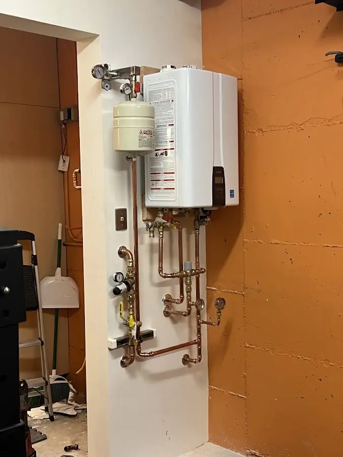 Plumbing technician inspecting water heater connections in Youngsville